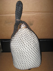 A fish in a fishnet stocking hanging from a hook.